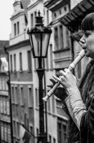 Una persona suona il flauto dolce su uno sfondo vintage di città